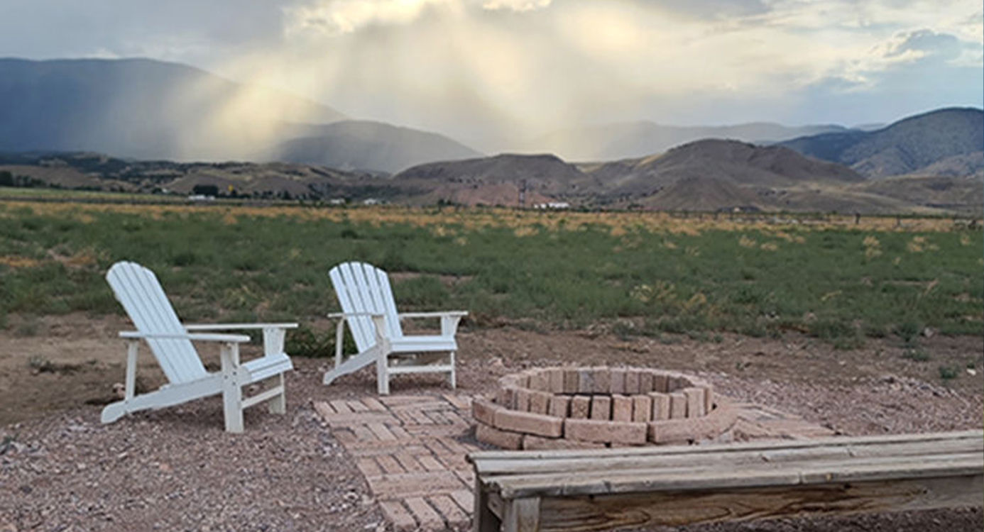 Fire pit and Adirondack chairs with mountain view at Marysvale